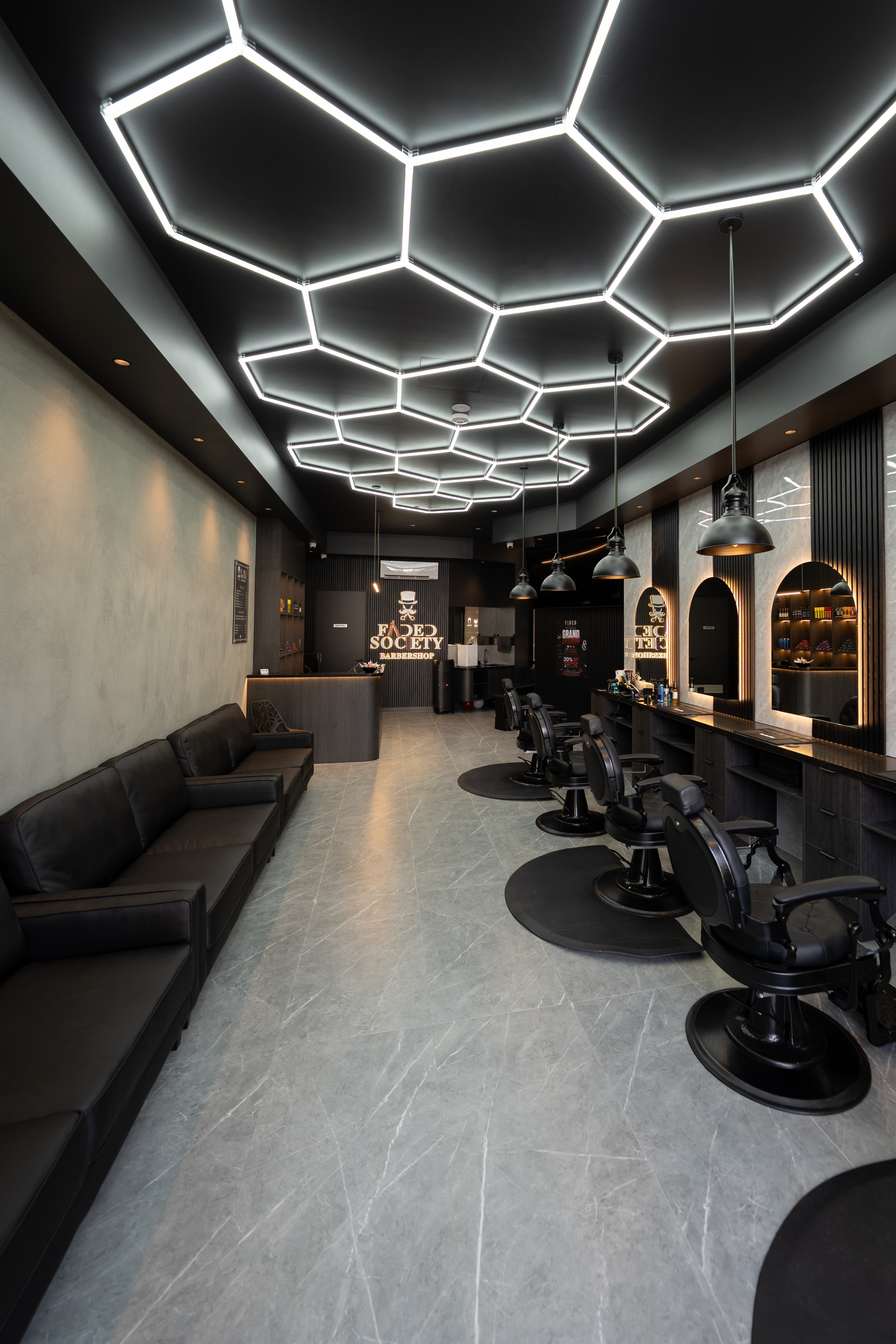 Barber at work detailing a client's cut at Faded Society
